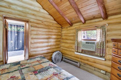 a bedroom with a bed in a log cabin at Rustic Bemidji Cabin with Boat and Lake Access! in Bemidji