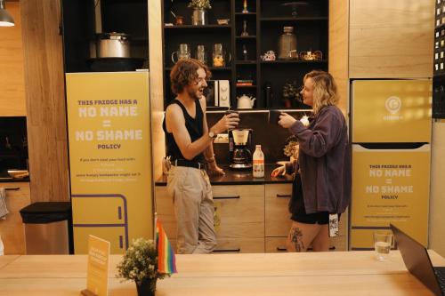 two people standing in a kitchen with a no shave sign at Onefam Paralelo in Barcelona