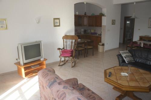 a living room with a couch and a tv at Suran Apartments in Pula