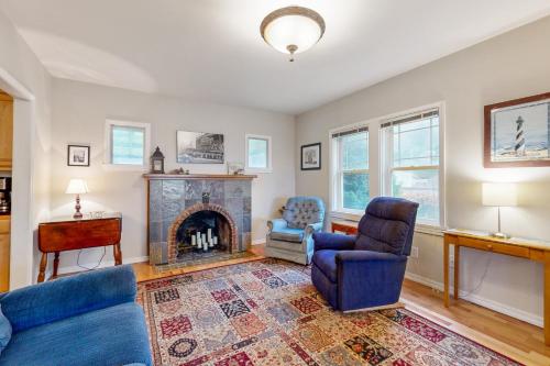 a living room with a fireplace and two chairs at Cliff Retreat in Rockaway Beach