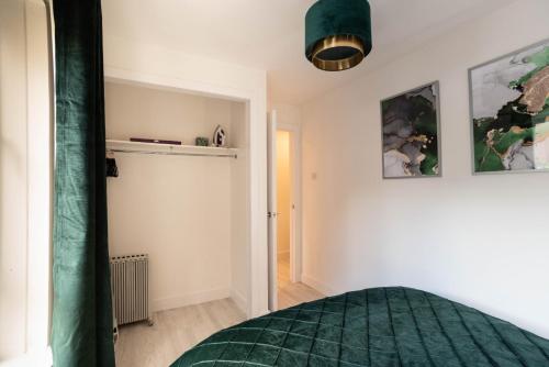 a bedroom with a green comforter on a bed at Glasgow City, West End, Private Parking in Glasgow