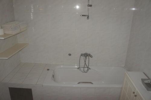 a white bath tub with a faucet in a bathroom at Suran Apartments in Pula