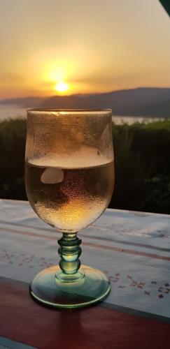 a wine glass with the sunset in the background at Résidence île de beauté in Propriano