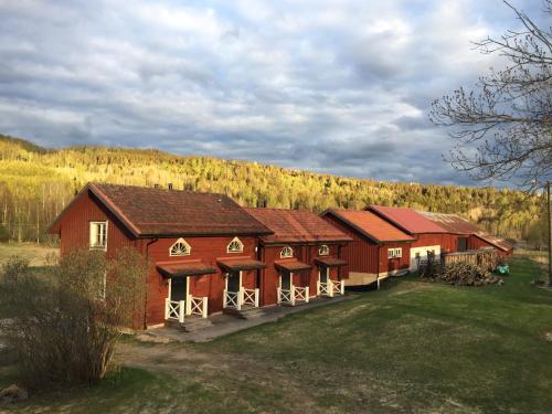 a group of red barns in a field at Markusfolks Gård in Torsby