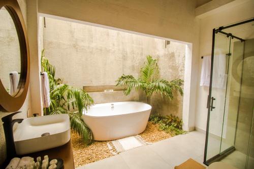 a bathroom with a bath tub and plants at LITERATIUM in Mompos