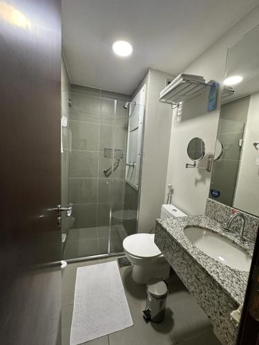 a bathroom with a shower and a toilet and a sink at Suíte com varanda em Via Premiere - Rio centro in Rio de Janeiro