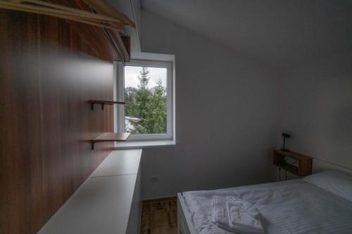 a bedroom with a bed and a window at Kuca 59 in Jahorina