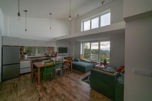 a kitchen and living room with a table and chairs at Kuca 59 in Jahorina