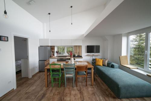 a kitchen and living room with a table and a couch at Kuca 59 in Jahorina