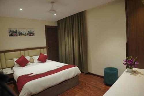 a hotel room with a large bed with red pillows at The Pride in Jamshedpur