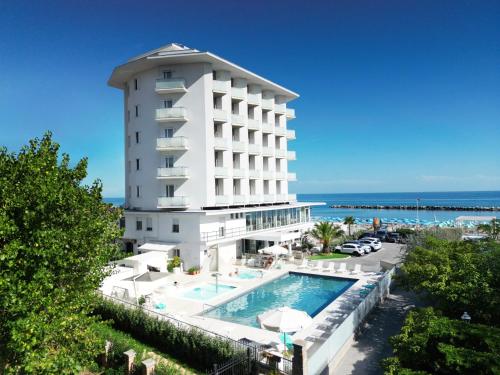a hotel with a swimming pool next to the ocean at Hotel Mexico in Bellaria-Igea Marina
