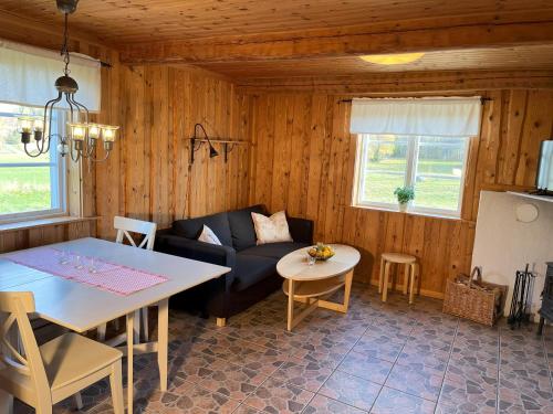 a living room with a couch and a table at Markusfolks Gård in Torsby