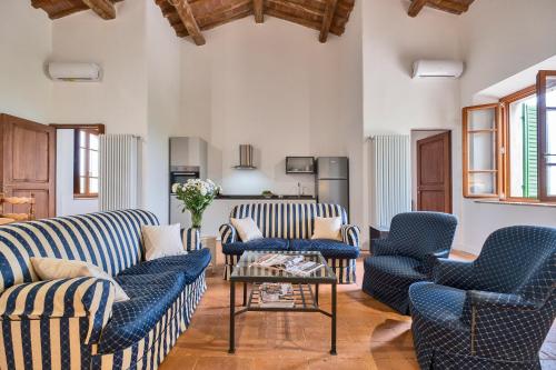 a living room with two blue chairs and a table at Tenuta di Megognano in Poggibonsi