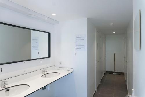 La salle de bains est pourvue de 2 lavabos et d'un grand miroir. dans l'établissement Tiendas safari Chill-Outdoor, à Perarrua