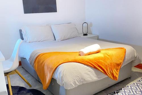 a bedroom with a bed with an orange blanket on it at Horizon Haven in Manchester