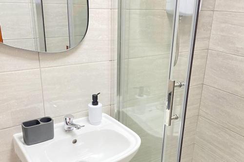 a bathroom with a sink and a shower with a mirror at Horizon Haven in Manchester