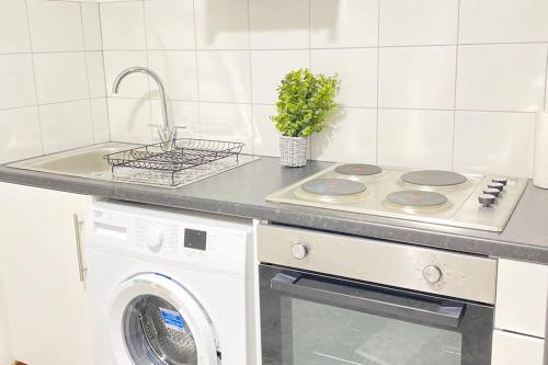 a kitchen with a stove and a washing machine at Horizon Haven in Manchester