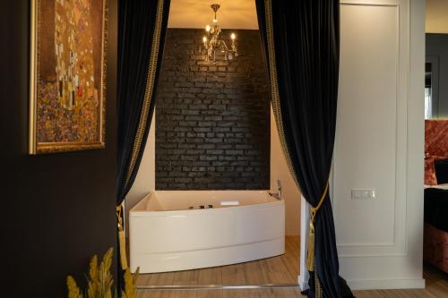 a bathtub in a room with a brick wall at Ribas Rooms Bila Tserkva in Bila Tserkva