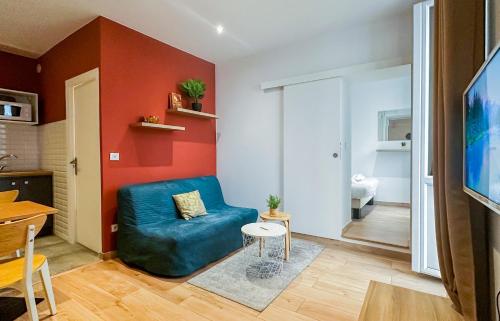 un salon avec un canapé bleu et une table dans l'établissement Teranga au coeur de la ville, à Annecy