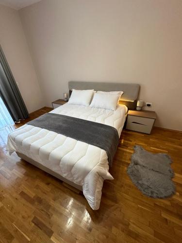 1 dormitorio con 1 cama grande con sábanas blancas en Villa Malo Guesthouse en Korçë
