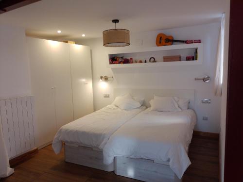 a bedroom with a large bed with white sheets at Atalaya in Mundaka
