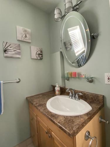 a bathroom with a sink and a mirror at Private Room- Shediac Beach House in Shediac