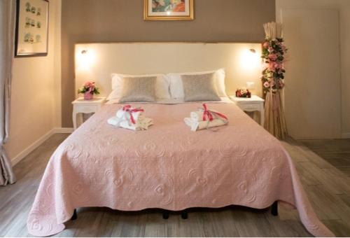 a bedroom with a pink bed with two towels on it at L'artè in Cascina