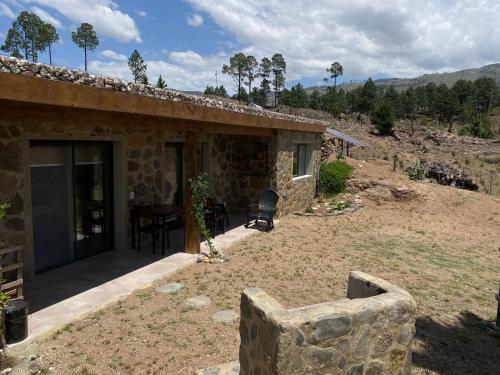 Casa de piedra con patio y mesa en Cabana Villa Alpina en Villa Alpina