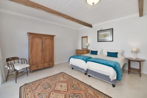 a bedroom with a bed and a chair in it at Sundew In Arniston in Arniston