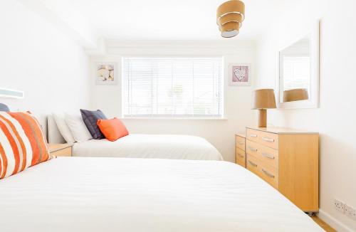 a bedroom with two beds and a couch at 3 Europa Court, in Mawgan Porth