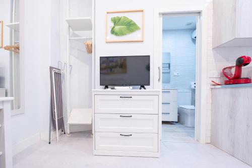 a living room with a tv on a white dresser at ABC Apartments Madrid in Madrid