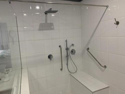 uma casa de banho com um chuveiro e uma porta de vidro em Ecolux em Marracuene
