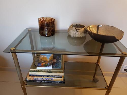 a glass table with books and vases on it at The Superstay Boutique guestroom in Amsterdam