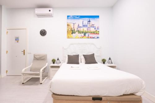 マドリードにあるABC Apartments Madridの白いベッドルーム(ベッド1台、椅子付)