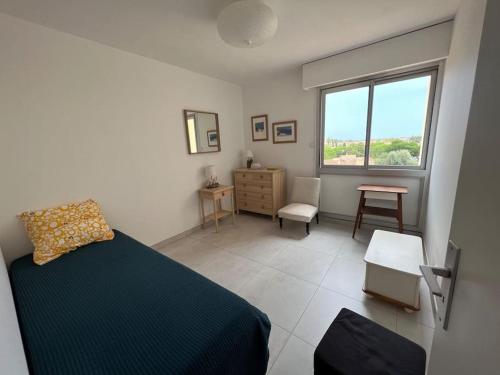 une chambre avec un lit, un bureau et une fenêtre dans l'établissement Très bel appartement centre-ville pour 4 personnes, à La Londe-les-Maures