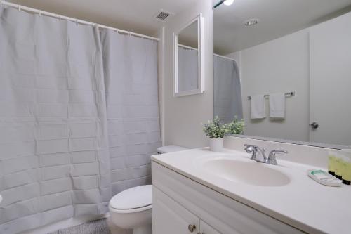 een witte badkamer met een toilet en een wastafel bij Located Crystal City Apt with Dazzling Amenities in Arlington