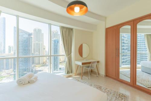 a bedroom with a white bed and a large window at LUXFolio Retreats - Spacious Luxury Unit - 3BHK in Dubai