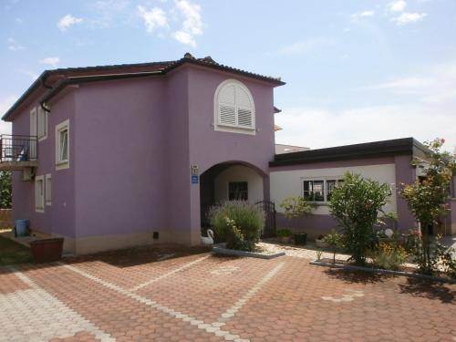 a pink house with a brick driveway at Villa Lory Krk in Krk