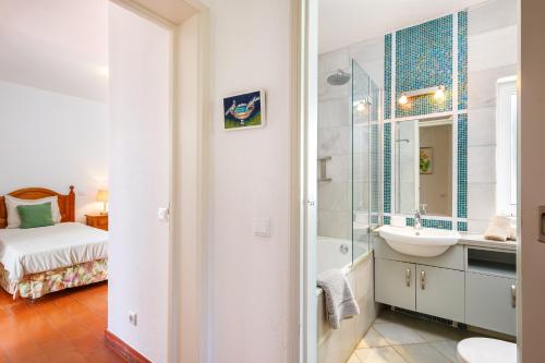 uma casa de banho com um lavatório e um espelho em Villa Quadradinhos 38Q - great 4BR Vale do Lobo villa with AC Private Pool no Vale do Lobo
