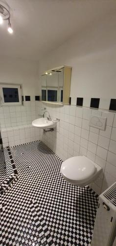 La salle de bains est pourvue de toilettes, d'un lavabo et d'un miroir. dans l'établissement Ferienwohnung auf dem Land Schermbeck Moviepark, à Schermbeck