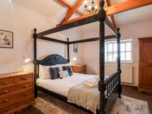 a bedroom with a four poster bed and a dresser at Guillemot in Bridlington