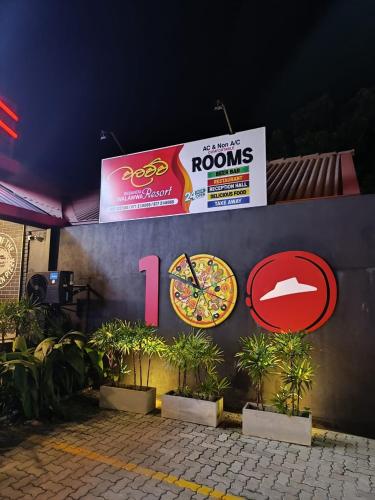 a wall with a pizza sign and a clock on it at Desandu Walawwa Resort in Kurunegala