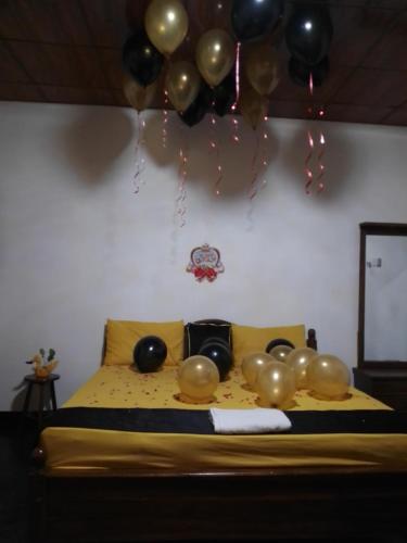 a bed with black and gold balloons on it at Desandu Walawwa Resort in Kurunegala