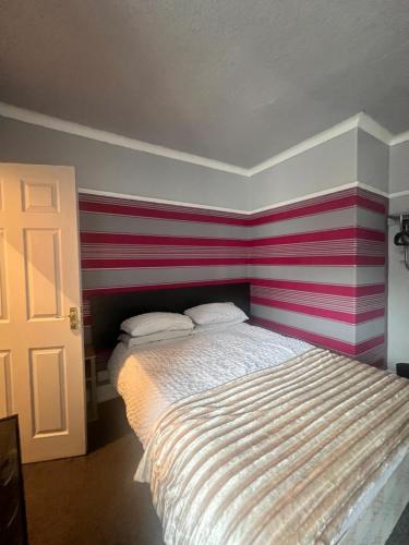 Ce lit se trouve dans un dortoir doté d'un mur rayé. dans l'établissement No 1 Lord Street, à Blackpool