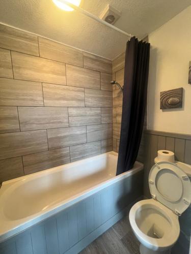 ein Badezimmer mit einem WC und einer Badewanne in der Unterkunft No 1 Lord Street in Blackpool
