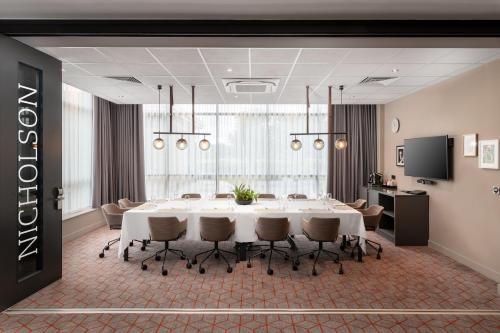 a conference room with a large white table and chairs at Hilton Garden Inn London Heathrow Airport in Hillingdon