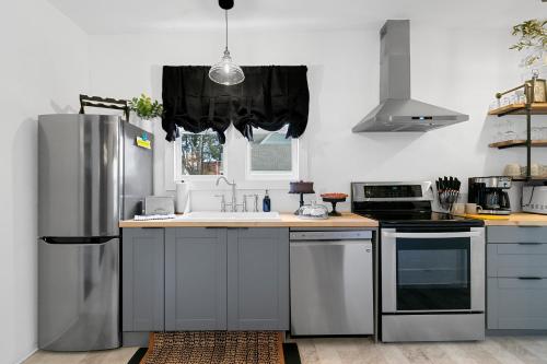 uma cozinha com um frigorífico de aço inoxidável e um lavatório em Compass Cove Downtown Home With Modern Updates em Sturgeon Bay