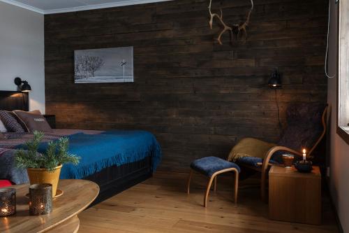 a bedroom with a bed and a wooden wall at Skoogs Logi - Rum in Funäsdalen