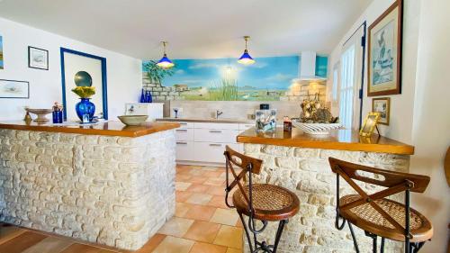 - une cuisine avec un comptoir et 2 chaises dans l'établissement Jolie villa proche des plages et pistes cyclables, à La Couarde-sur-Mer
