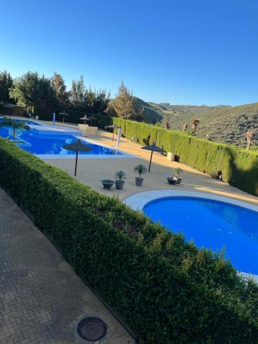 a row of three swimming pools with bushes at Apto. Residencial La Alcaidesa in La Alcaidesa